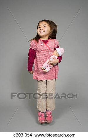 A girl holding a doll View Large Photo Image Picture - A girl holding a doll. Fotosearch
