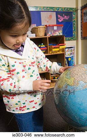 A girl looking at a globe View Large Photo Image Stock Photograph - A girl looking at a globe. Fotosearch