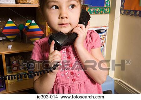 A girl using a telephone View Large Photo Image Picture - A girl using a telephone. Fotosearch