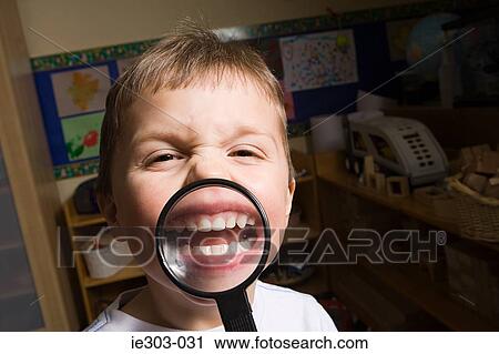Boy holding a magnifying glass View Large Photo Image Stock Image - Boy holding a magnifying glass. Fotosearch