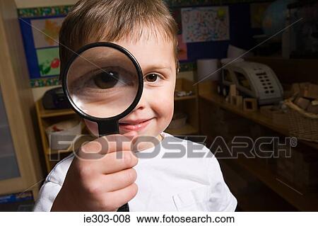 Boy holding a magnifying glass View Large Photo Image Stock Photo - Boy holding a magnifying glass. Fotosearch