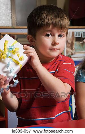 Boy holding a present View Large Photo Image Stock Photo - Boy holding a present. Fotosearch