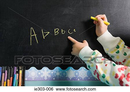 Girl writing on a blackboard View Large Photo Image Stock Photograph - Girl writing on a blackboard. Fotosearch
