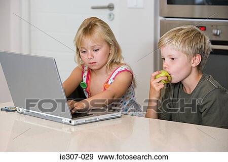 Stock Photo - A brother and sister using a laptop. Fotosearch