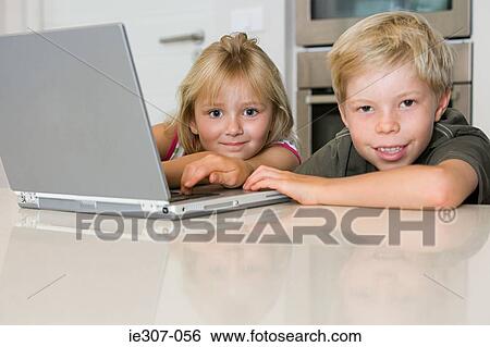 A brother and sister using a laptop View Large Photo Image Stock Photograph - A brother and sister using a laptop. Fotosearch