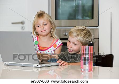 A brother and sister using a laptop View Large Photo Image Stock Photograph - A brother and sister using a laptop. Fotosearch
