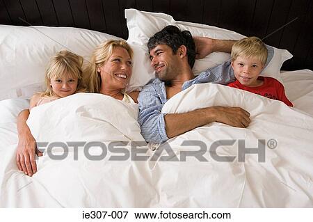 A family in bed View Large Photo Image Stock Photo - A family in bed. Fotosearch
