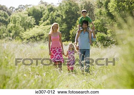 A family walking through a field View Large Photo Image Stock Image - A family walking through a field. Fotosearch