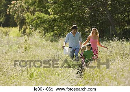 A family walking through a field View Large Photo Image Stock Photography - A family walking through a field. Fotosearch