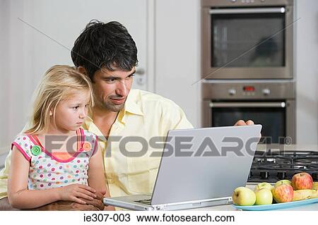 A father and daughter looking at a laptop View Large Photo Image Stock Image - A father and daughter looking at a laptop. Fotosearch