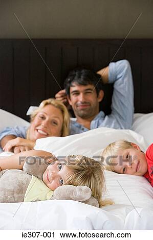 Portrait of a family in bed View Large Photo Image Stock Image - Portrait of a family in bed. Fotosearch