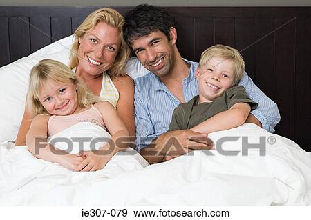 Portrait of a family in bed View Large Photo Image Stock Photo - Portrait of a family in bed. Fotosearch
