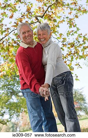 Senior couple dancing near a tree View Large Photo Image Stock Photo - Senior couple dancing near a tree. Fotosearch