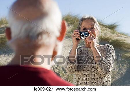 Senior couple photographing at beach View Large Photo Image Stock Photo - Senior couple photographing at beach. Fotosearch