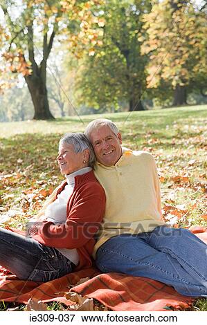 Senior couple relaxing in a park View Large Photo Image Stock Photo - Senior couple relaxing in a park. Fotosearch