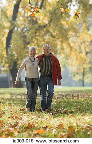 Senior couple walking in a park View Large Photo Image Stock Photo - Senior couple walking in a park. Fotosearch