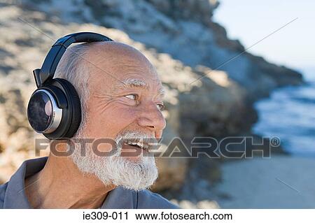Stock Image - Senior man listening to music. Fotosearch