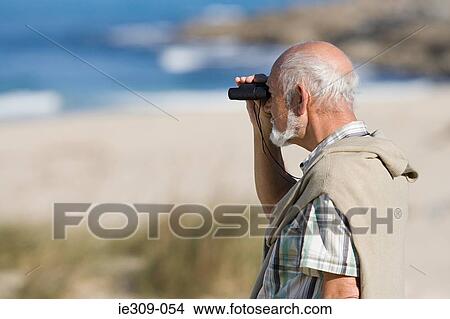 Senior man using binoculars View Large Photo Image Picture - Senior man using binoculars. Fotosearch