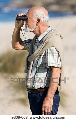 Senior man using binoculars View Large Photo Image Stock Photo - Senior man using binoculars. Fotosearch