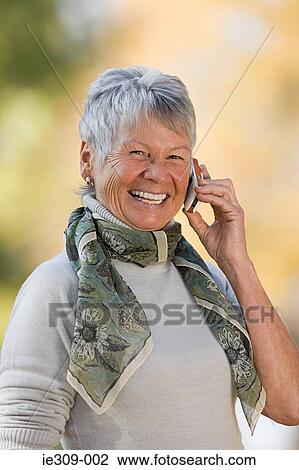 Smiling senior woman using a cell phone View Large Photo Image Stock Image - Smiling senior woman using a cell phone. Fotosearch