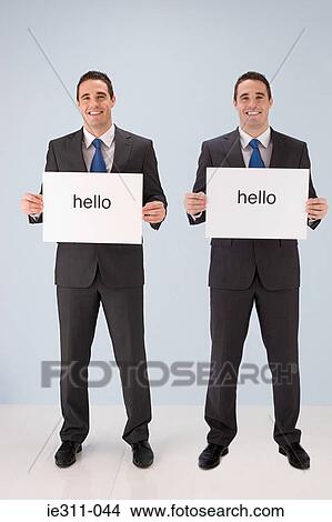 Businessmen holding hello signs View Large Photo Image Picture - Businessmen holding hello signs. Fotosearch