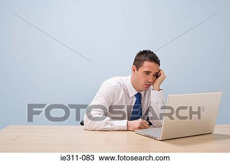 Stock Image - Fed up man with laptop. Fotosearch