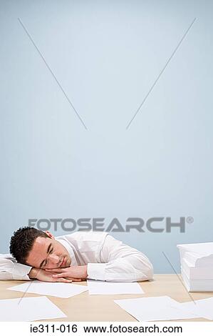 Stock Photograph - Office worker sleeping on desk. Fotosearch