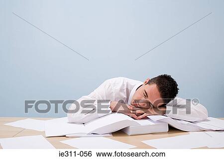 Stock Photograph - Office worker sleeping on desk. Fotosearch