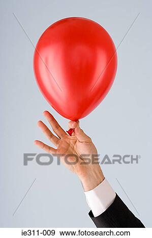 Stock Photo - Person holding a balloon. Fotosearch