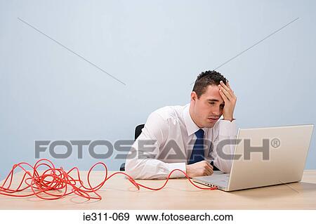 Stressed man looking at laptop View Large Photo Image Stock Photo - Stressed man looking at laptop. Fotosearch
