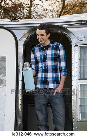 A teenage boy holding a flask View Large Photo Image Stock Photograph - A teenage boy holding a flask. Fotosearch