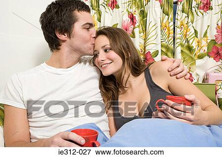 Stock Photo - A teenage boy kissing a teenage girl on the head. Fotosearch