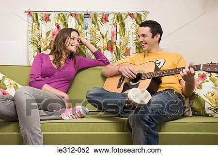 A teenage boy playing a guitar for a teenage girl View Large Photo Image Stock Image - A teenage boy playing a guitar for a teenage girl. Fotosearch