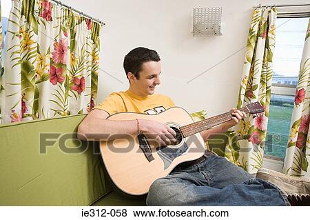 A teenage boy playing a guitar View Large Photo Image Stock Photo - A teenage boy playing a guitar. Fotosearch