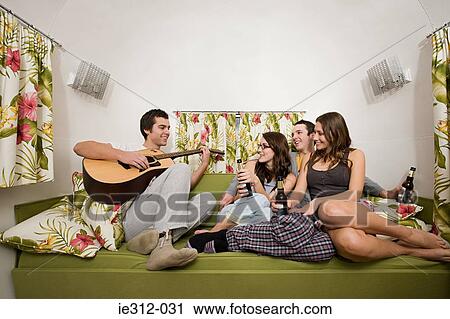 A teenage boy playing the guitar for his friends View Large Photo Image Stock Image - A teenage boy playing the guitar for his friends. Fotosearch