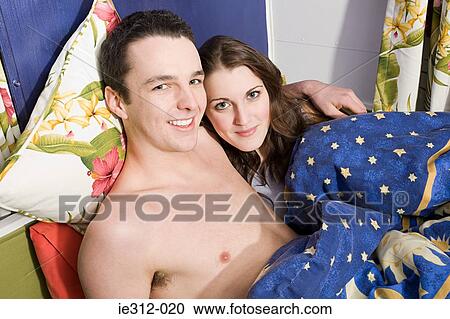 Stock Image - A teenage couple in bed. Fotosearch