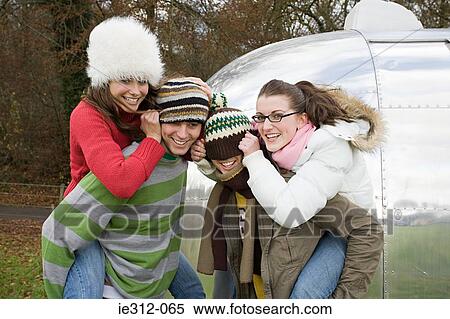 Stock Photography - Teenage boys giving teenage girls piggybacks. Fotosearch