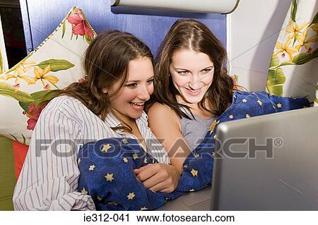 Teenage girls looking at a laptop View Large Photo Image Stock Image - Teenage girls looking at a laptop. Fotosearch