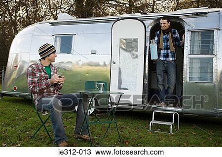 Stock Image - Two teenage boys and a caravan. Fotosearch