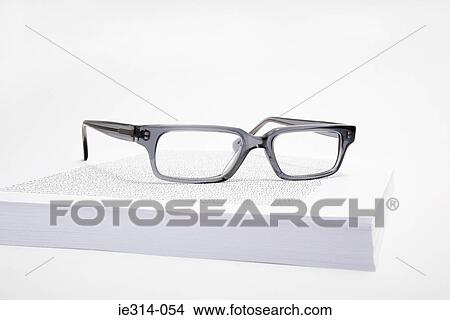 Picture - Eyeglasses and a stack of paper . Fotosearch
