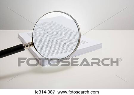 Magnifying glass and a stack of paper View Large Photo Image Stock Photo - Magnifying glass and a stack of paper. Fotosearch