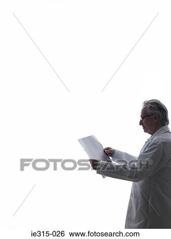 Doctor looking at paper View Large Photo Image Stock Photograph - Doctor looking at paper. Fotosearch