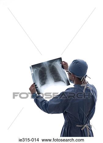 Surgeon looking at x-ray View Large Photo Image Picture - Surgeon looking at x-ray. Fotosearch
