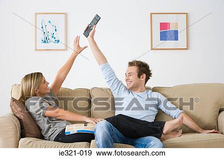 A couple fooling around with a remote control View Large Photo Image Stock Photo - A couple fooling around with a remote control. Fotosearch