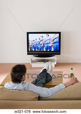 A man watching a football match on the tv View Large Photo Image Stock Photo - A man watching a football match on the tv. Fotosearch