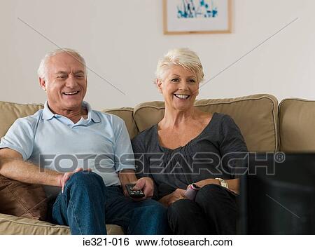 Stock Photograph - A senior couple watching tv. Fotosearch