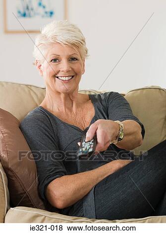 A senior woman watching tv View Large Photo Image Stock Photo - A senior woman watching tv. Fotosearch