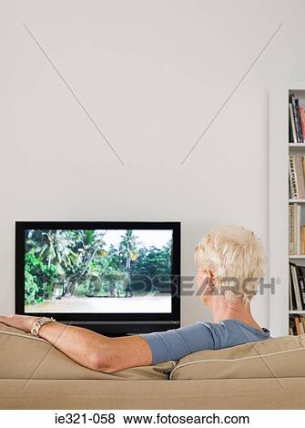 A senior woman watching tv View Large Photo Image Stock Photo - A senior woman watching tv. Fotosearch