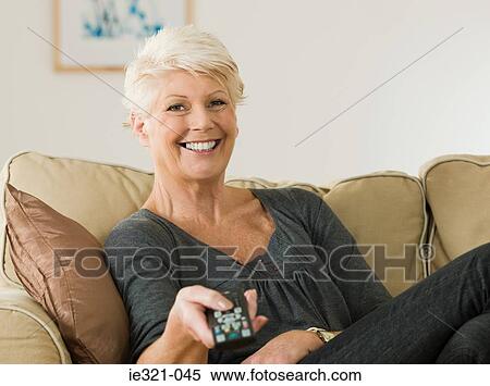 A senior woman watching tv View Large Photo Image Stock Photography - A senior woman watching tv. Fotosearch
