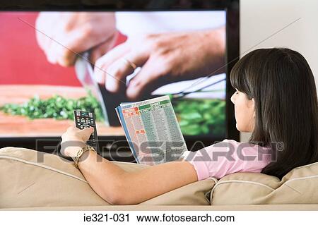A woman reading a tv listings magazine View Large Photo Image Stock Image - A woman reading a tv listings magazine. Fotosearch